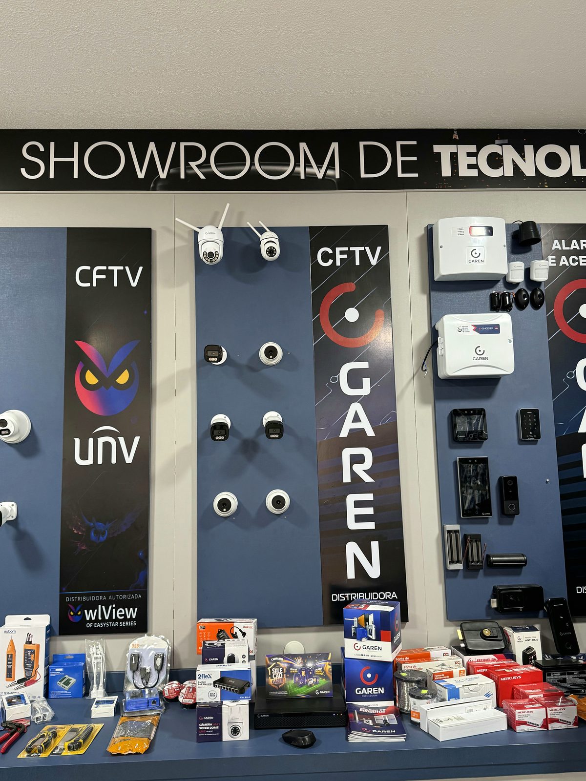 Painel de CFTV e acesso da Distribuidora Garen, com câmeras e produtos em exposição